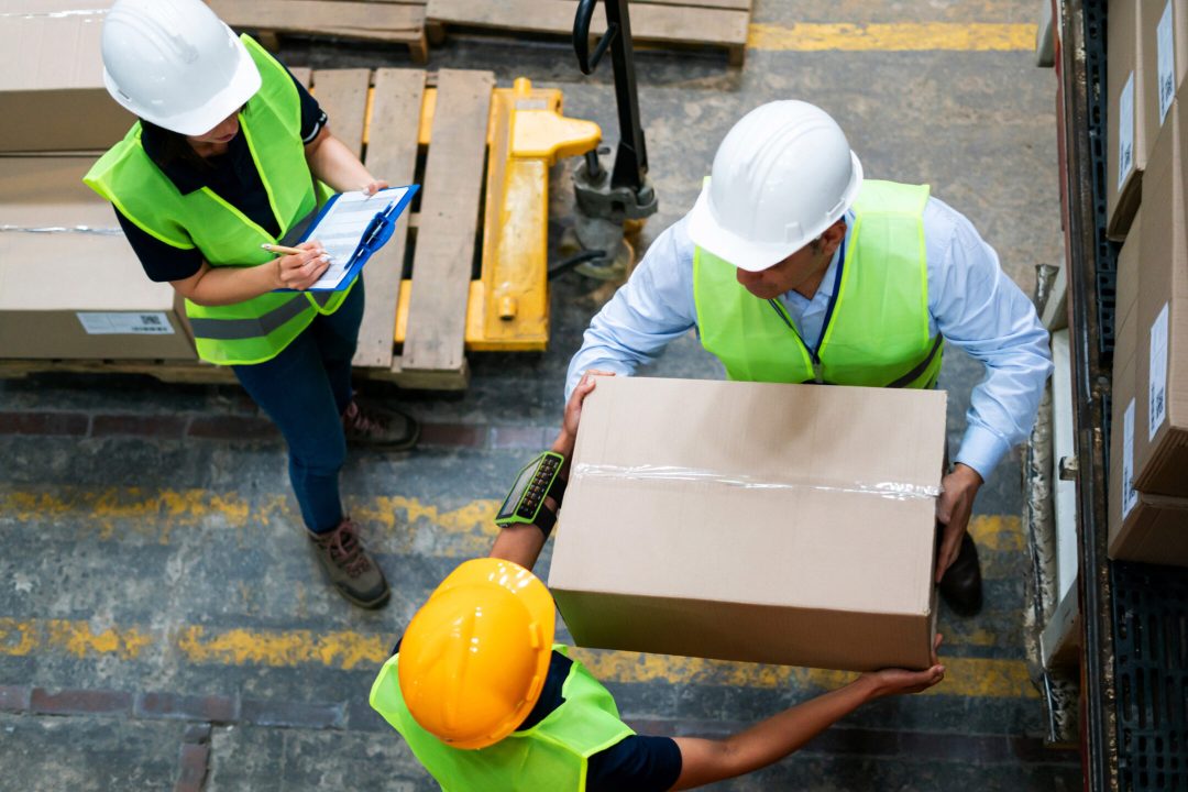 Workers with Zebra mobile computer unloading a forklift in a warehouse